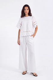 White Short-Sleeve Blouse with Cutwork Embroidery and Ruffled Hem on model, studio view 4 – Elppis 1B5E09174WW-01CM