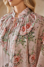 Close-up of the ruffled neckline and rose print chiffon fabric