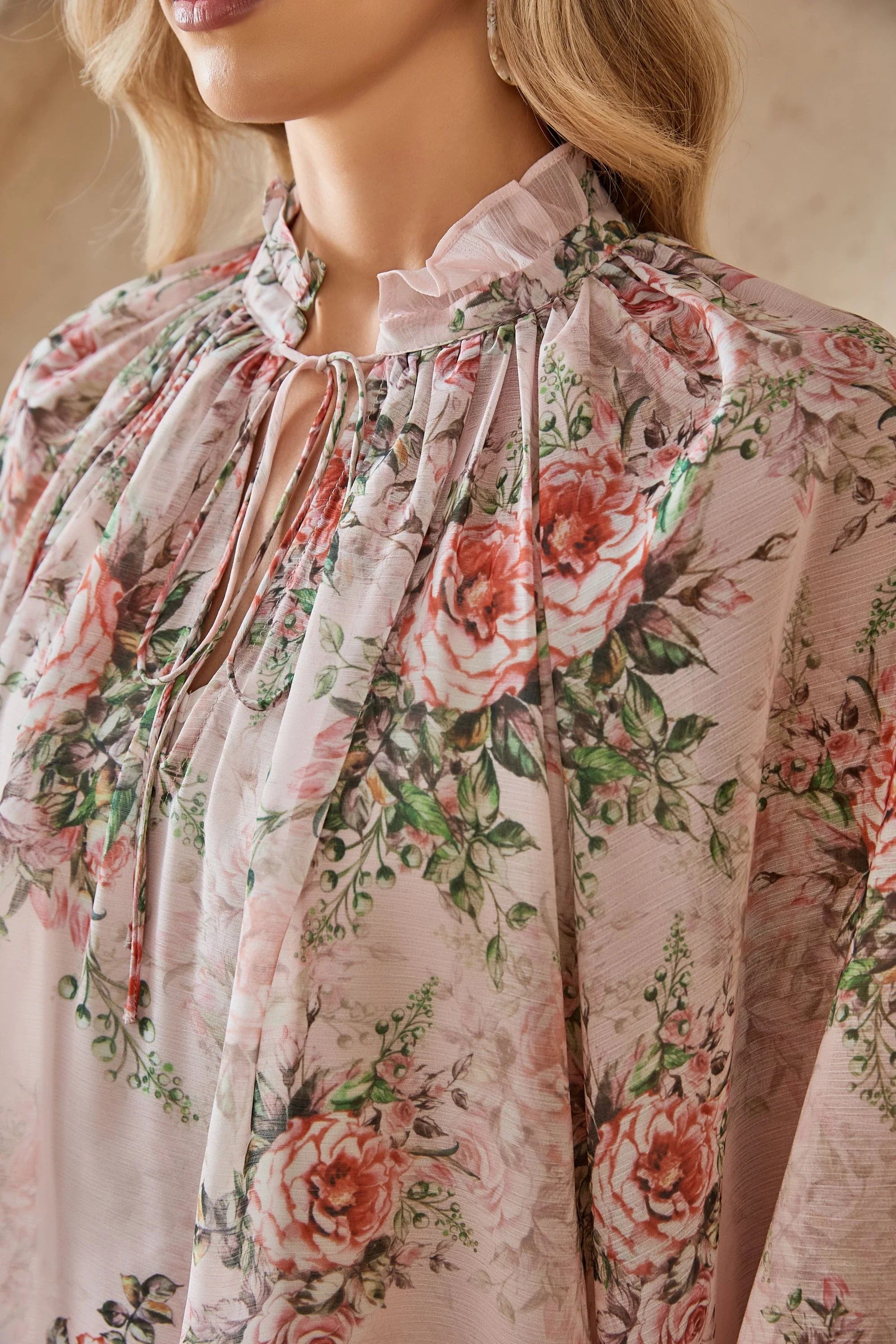 Close-up of the ruffled neckline and rose print chiffon fabric