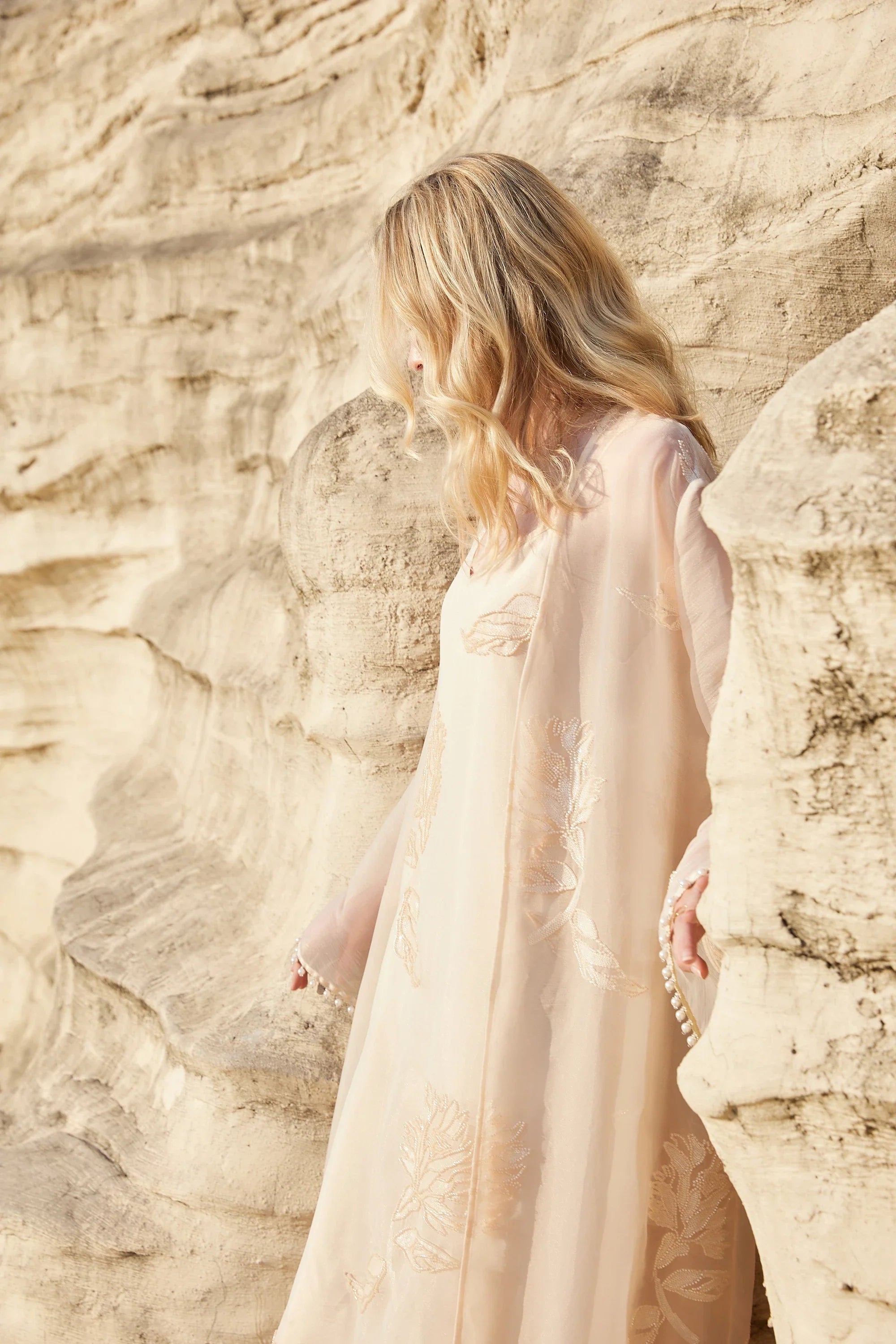 Model view highlighting the gold leaf embroidery on the blush pink slip dress