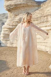 Lifestyle view of the Elppis blush pink sheer midi slip dress