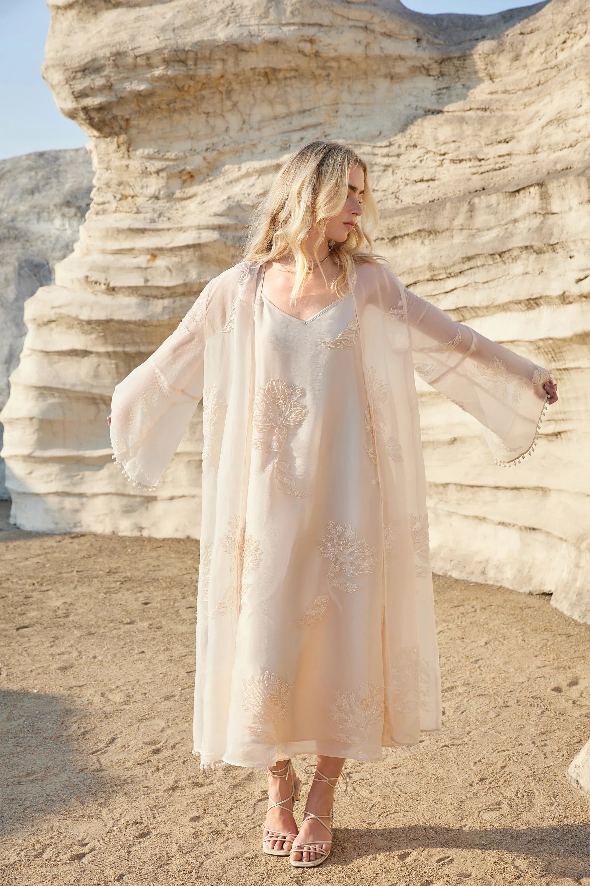 Lifestyle view of the Elppis blush pink sheer midi slip dress