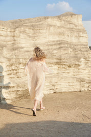 Back outdoor view of the Elppis blush pink sheer midi slip dress