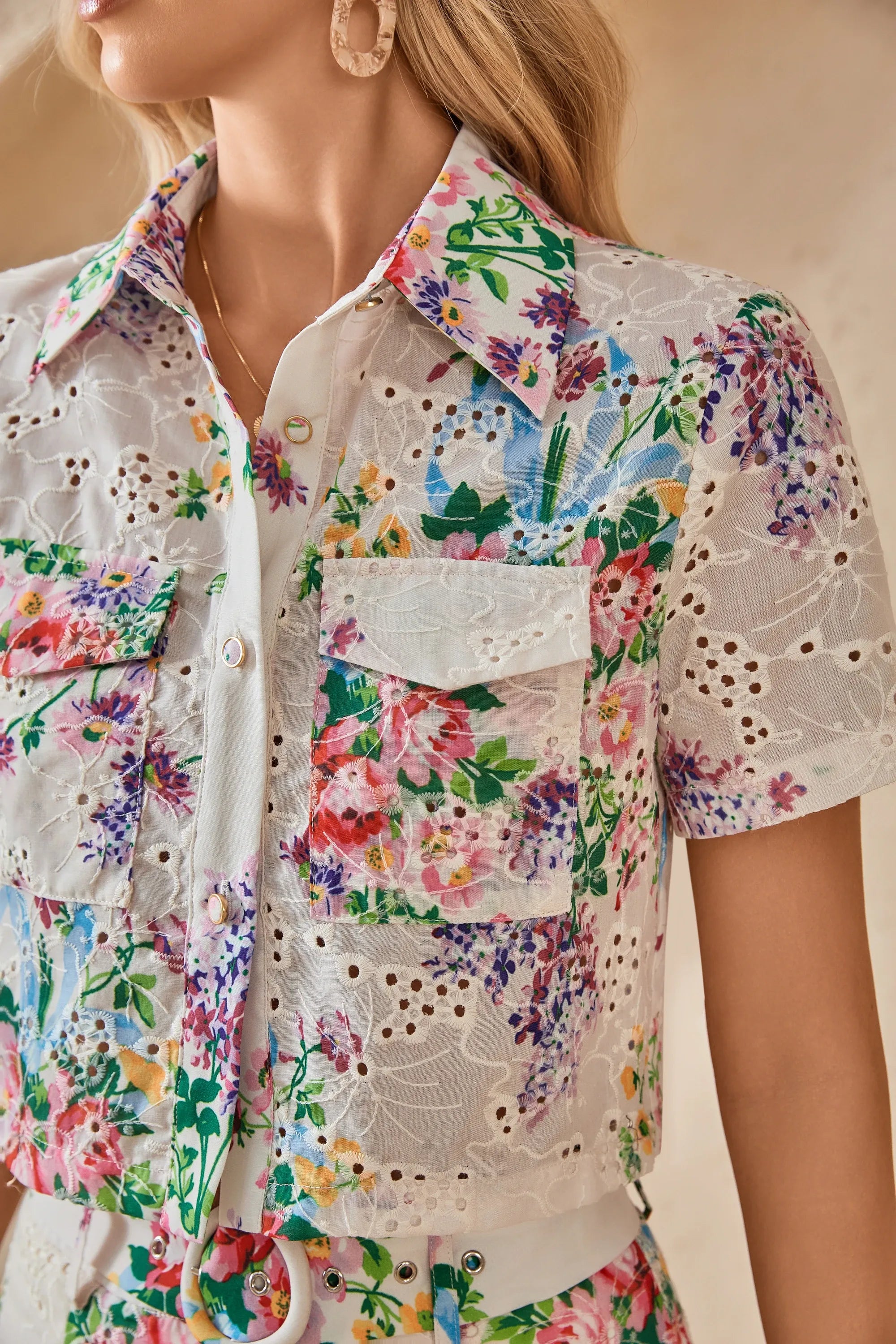 Close-up of the collar and front pockets on the floral eyelet cropped shirt