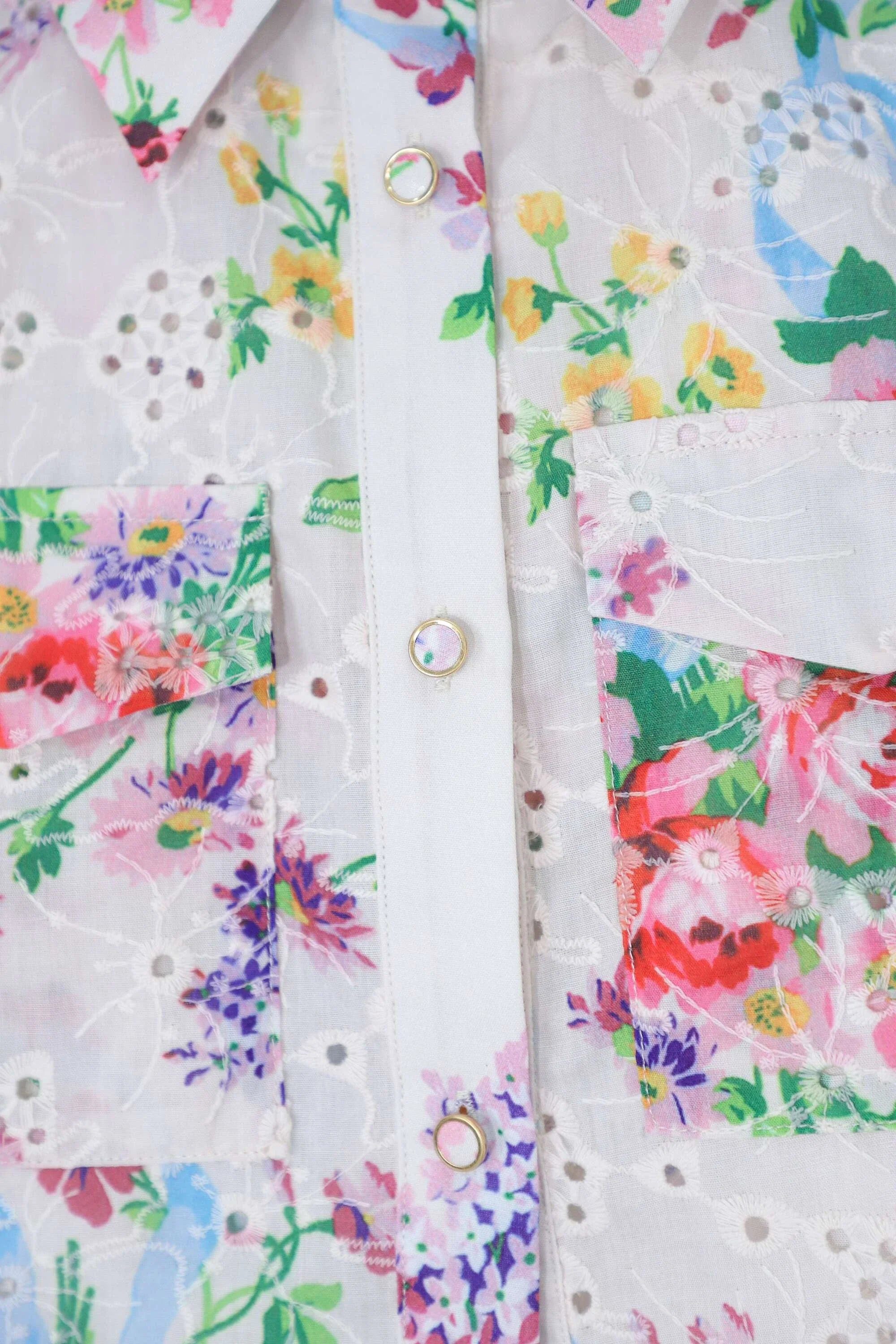 Detailed view of the floral print pocket and button front on the cropped shirt