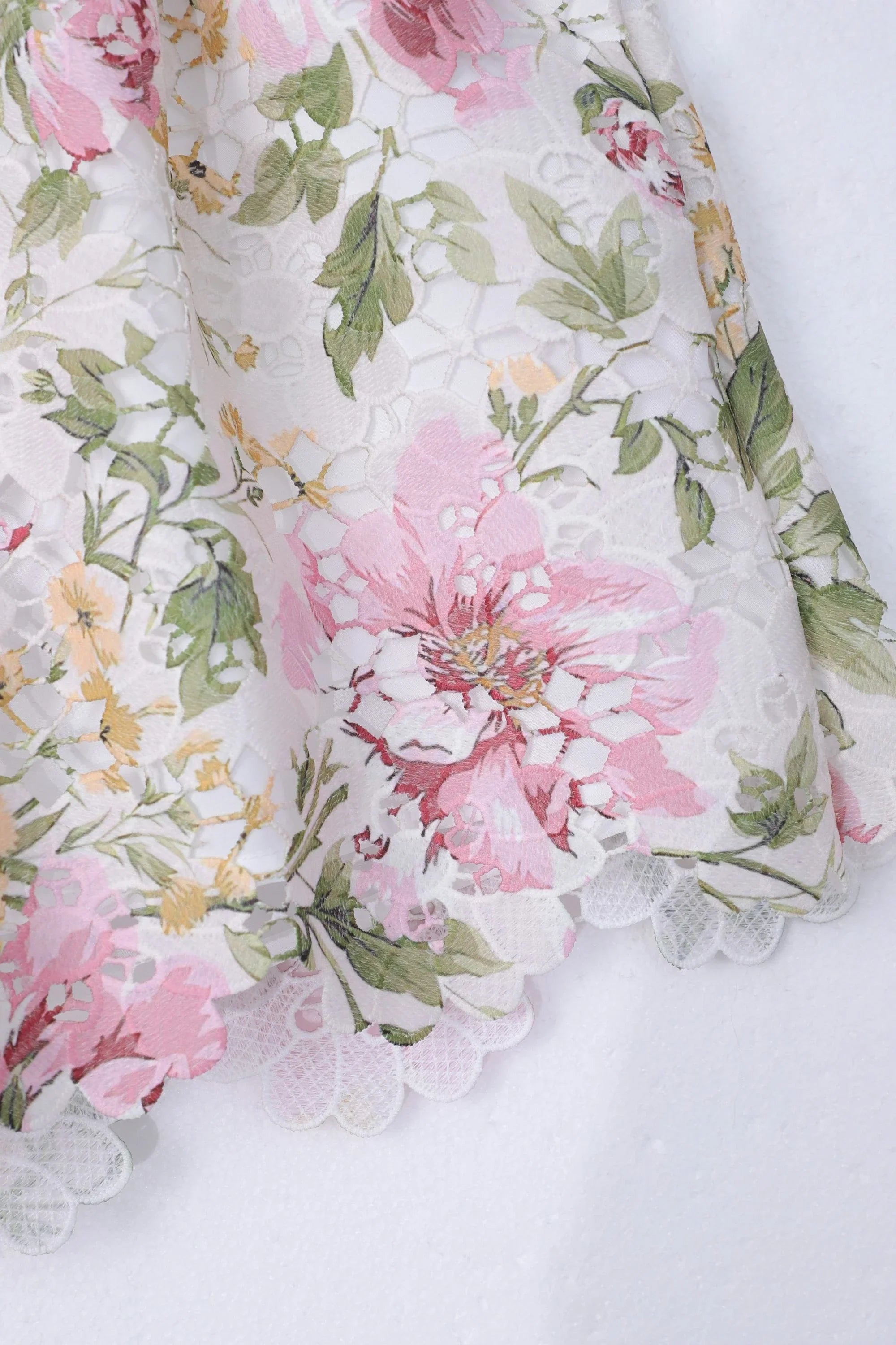 Close-up of the floral eyelet lace fabric and scalloped embroidery